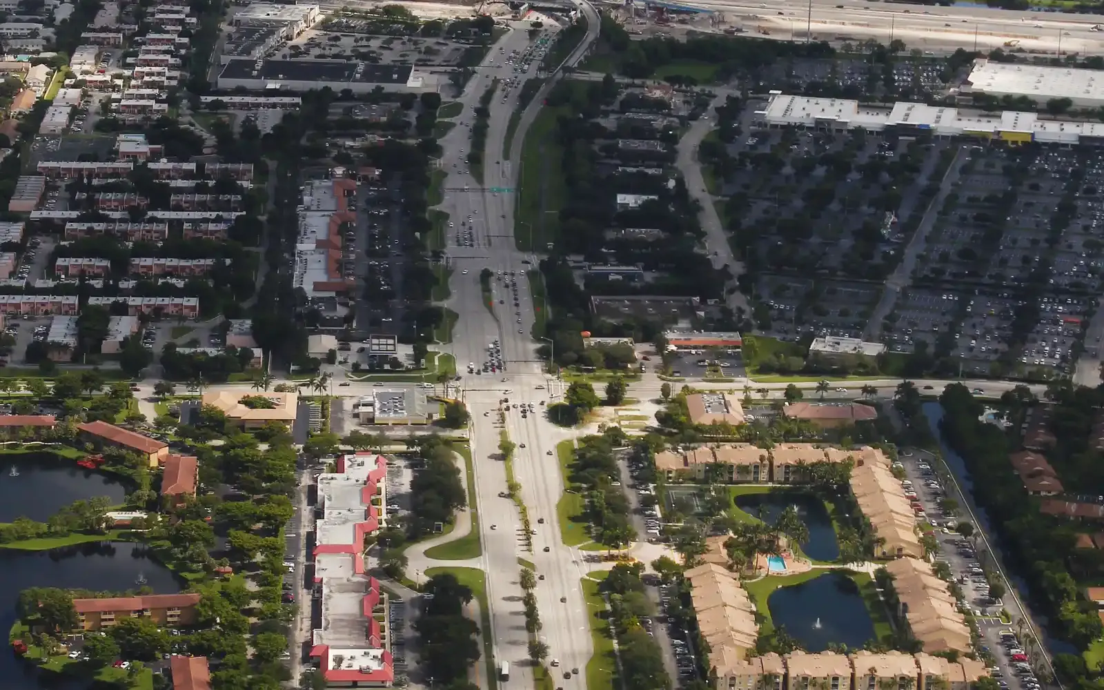 University Drive in Davie seen from the air, with apartment complexes and shopping plazas on both sides.